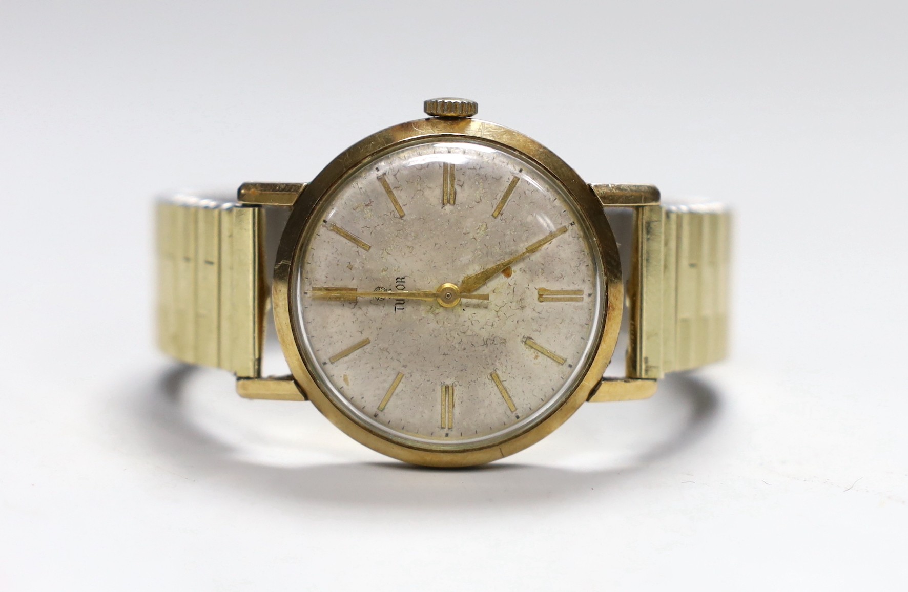 A gentleman's 1950's/1960's 9ct gold Tudor manual wind wrist watch, with baton numerals, and case back inscription, on associated flexible strap, case diameter 32mm.